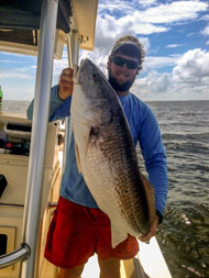 Chris holding a large red drum, Blue Ocean Market, Morehead City, NC